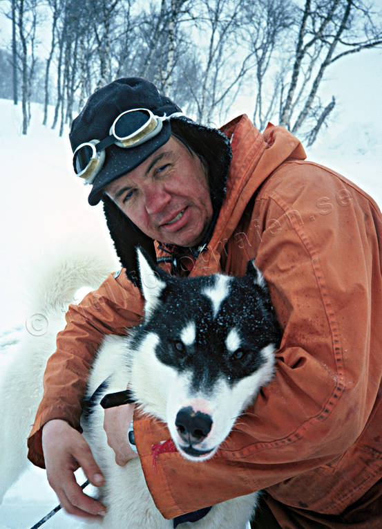 Draghundförare med grönlandshund draghundar, draghundtur, fjällfolk, fjällräddning, hundförare, kallt, oväder, porträtt, slädhund, slädhundar, slädhundtur, snö, snöstorm, storm, uteliv, vinter, äventyr