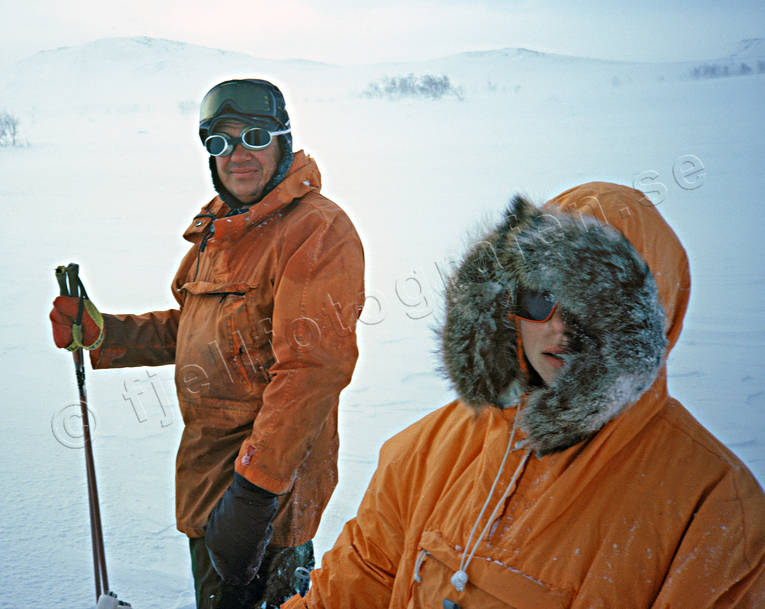 Fjällfarare i storm blåsväder, draghund, draghundar, draghundtur, fjäll, fjällfolk, fjällräddning, fjälltur, kallt, kvinna, man, oväder, par, porträtt, slädhund, slädhundar, snö, snöstorm, storm, uteliv, vinter, äventyr