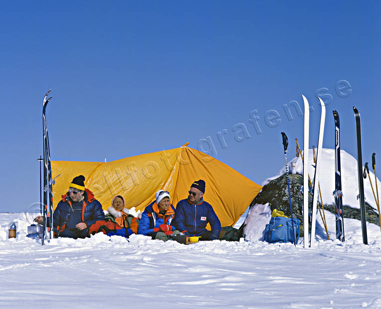 Fjällturister i vindskydd fjäll, fjälltur, fjällturism, fjällturister, skidor, skidåkning, sola, solbada, turister, turåkare, turåkning, uteliv, vindskydd, vinter, äventyr