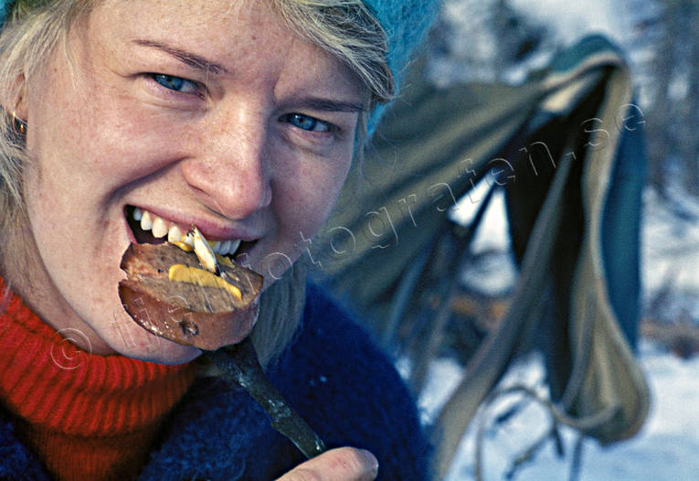 Flicka äter grillad korv flicka, friluftsliv, glad, gott, grilla, grillkorv, korv, smaka, ute, uteliv, vinter, vintersport, äta, äventyr