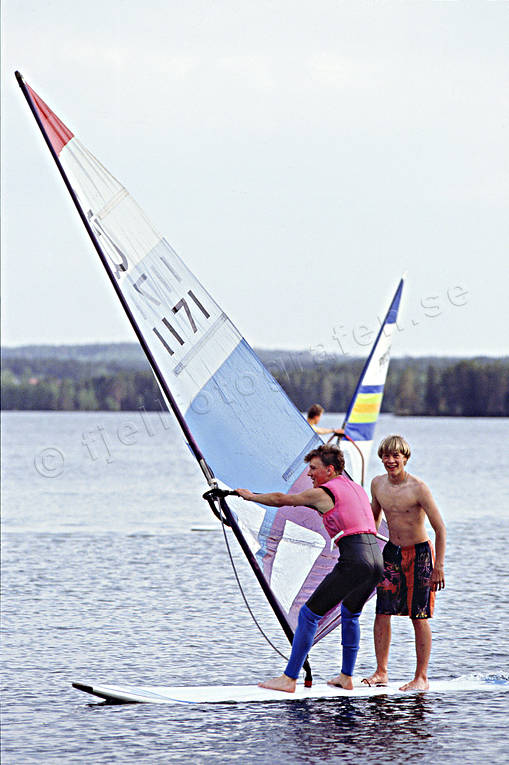 Pojkar på windsurfingbräda bad, friluftsliv, kultur, nutid, sommar, surfa, uteliv, windsurfing