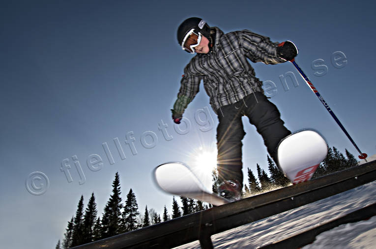 barn, bl himmel, fritid, hopp, jibb, jibbing, motljus, offpist, pojke, rail, rls, skidor, skidkare, skidkning, sol, sport, utfrskning, vinter