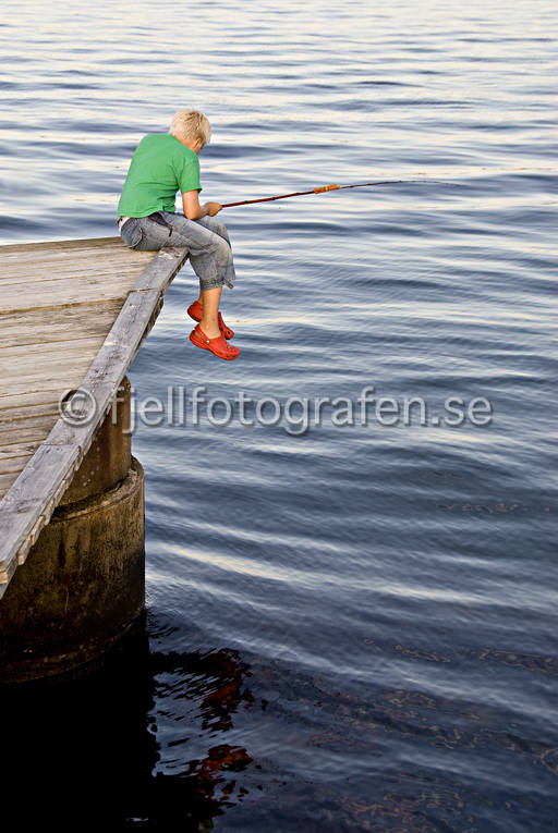 Pojke sitter på brygga och fiskar brygga, ensam, fisk, fiska, fiskare, hav, kust, meta, metspö, pojke