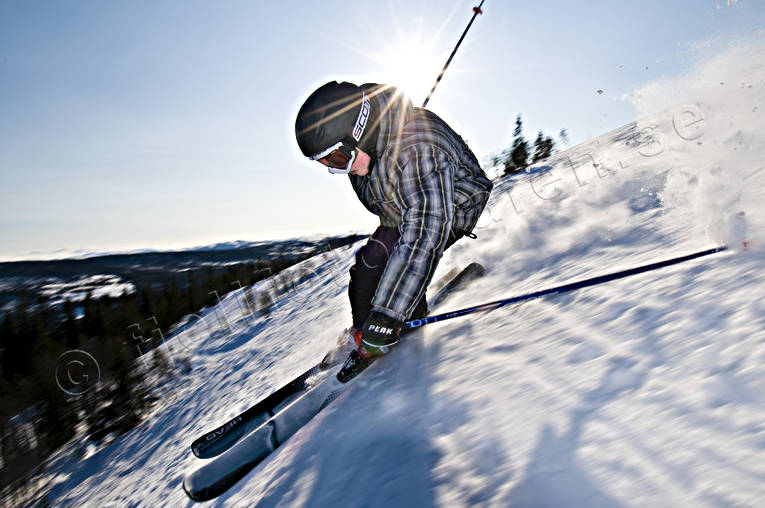 Pojke åker skidor backe, barn, blå himmel, fart, hopp, motljus, offpist, pojke, rail, räls, skidor, skidåkare, skidåkning, snösprut, sol, sport, utförsåkning, vinter