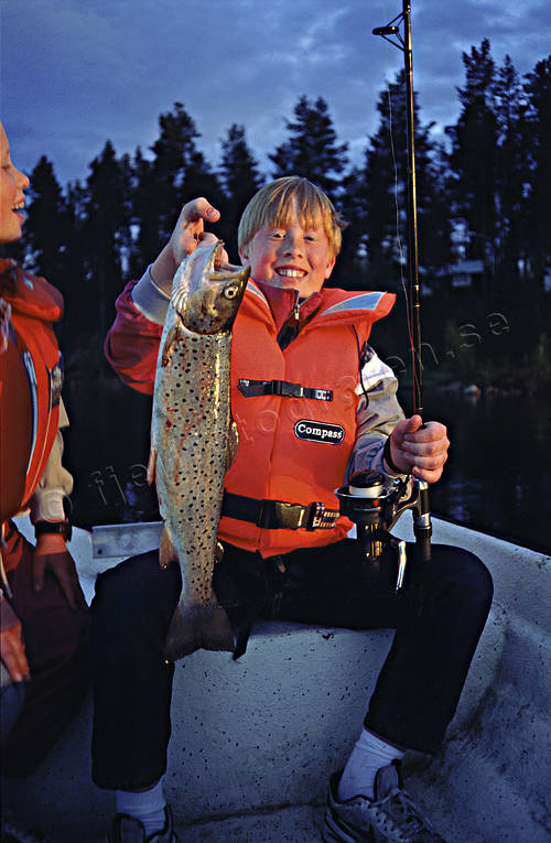 Ung pojke med fiskad öring barn, fiske, haspel, haspelfiske, Patrik Lundgren, pojke, spinn, spinnfiske, sportfiske, öring